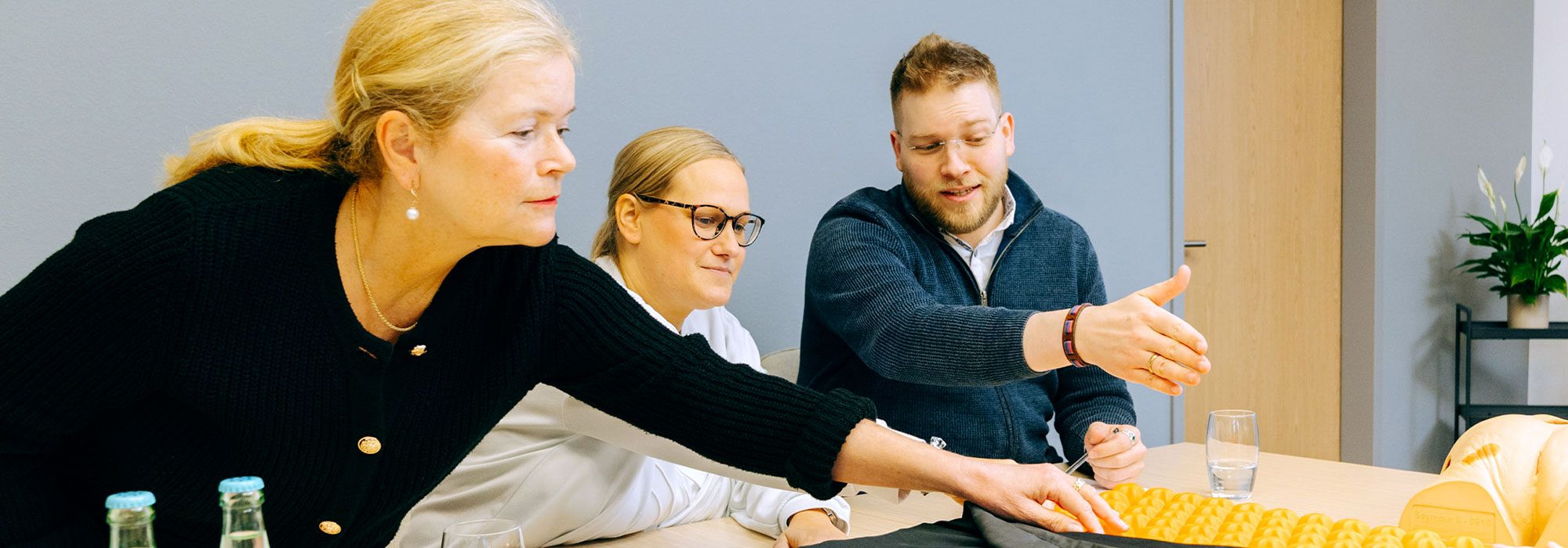 Carenetic Mitarbeitende besprechen an einem Tisch Antidekubitus-Hilfsmittel