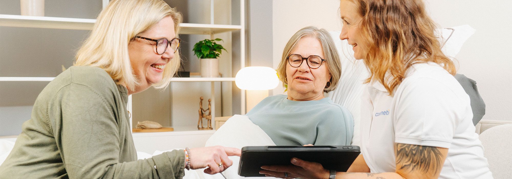 Carenetic employee advising a patient and her relative with a tablet