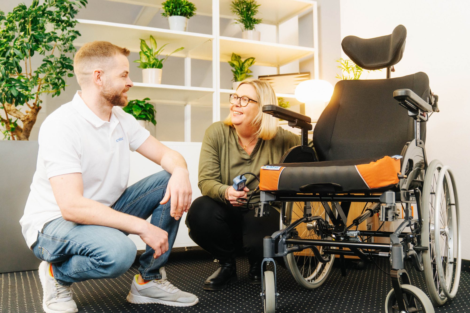 Carenetic Mitarbeiter erklärt einer Kundin die Druckeinstellung eines Rollstuhl-Sitzkissens