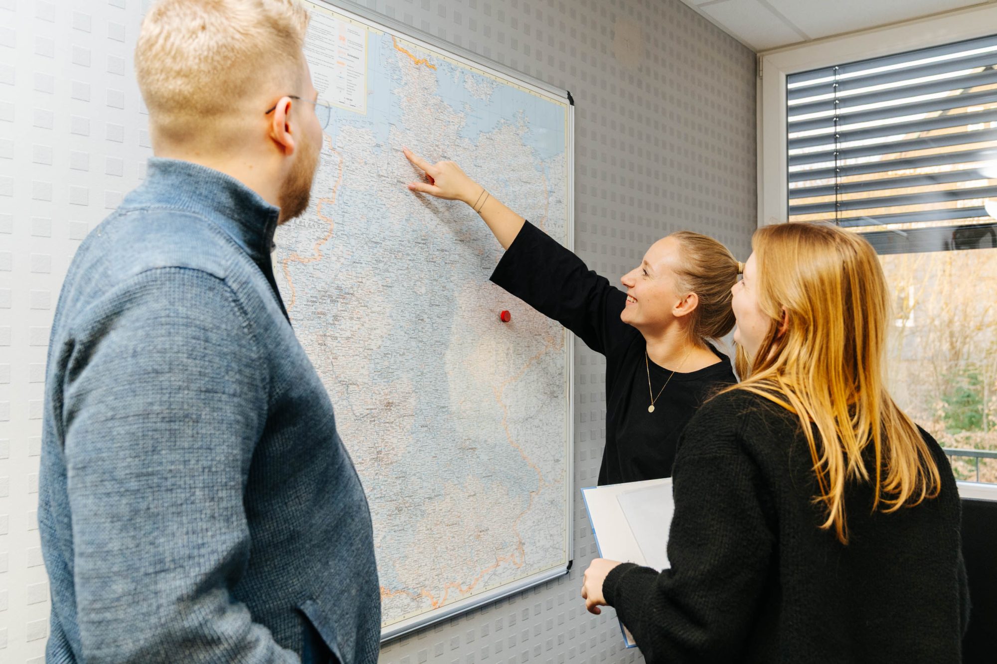Carenetic Team bespricht vor einer Deutschlandkarte die Versorgungsgebiete