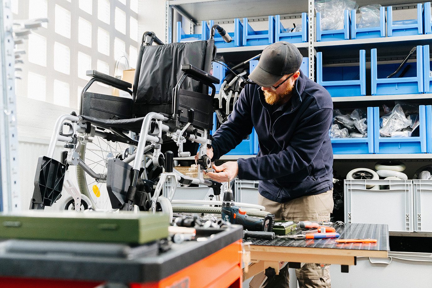 Carenetic Techniker repariert einen Rollstuhl in der Werkstatt