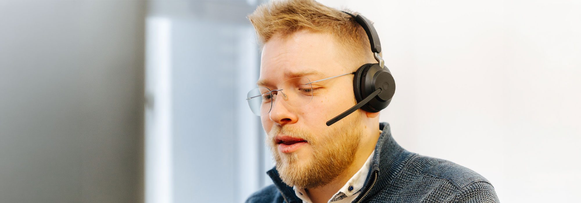 Carenetic Mitarbeiter mit Headset berät am Telefon